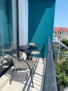 a patio with two chairs and a table on a balcony at Eric Apartment in Mamaia Nord