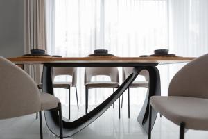 una mesa de comedor con sillas blancas alrededor en ApartamentyIn Belnihel, en Hel