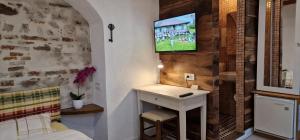a room with a tv on a wall with a desk at Guesthouse Postavarului in Braşov