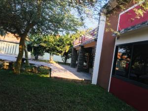 ein Gebäude mit einem Baum neben einem Hof in der Unterkunft Batoka Apartments in Lusaka