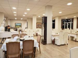 a dining room with white tables and white chairs at Hotel Bluebell in Ohrid