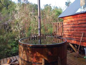 barril de madera con bañera de pájaro en la cubierta en Refugio y Tinaja Curiñanco, en Valdivia
