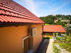 ツェリェにあるSmall house in Celjeの赤い屋根のオレンジハウスで、パティオが付いています。