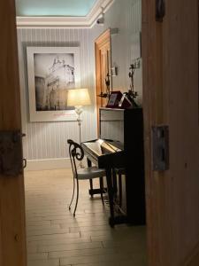 una camera con pianoforte e scrivania con lampada di B&B Porta Baresana a Bitonto