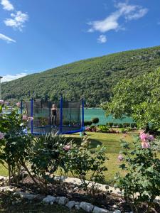 a man standing on a blue playground in a garden at Apartment Ombla in Mokošica
