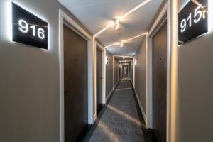 a corridor in a hotel with signs on the wall at Sandman Signature Glasgow Hotel in Glasgow