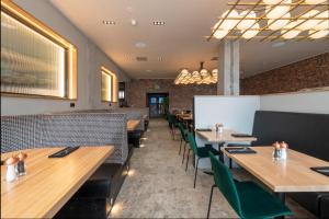 a dining room with wooden tables and green chairs at Sandman Signature Glasgow Hotel in Glasgow