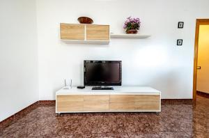 een woonkamer met een tv op een witte kast bij Les Olles Riumar Pura Natura in Riumar