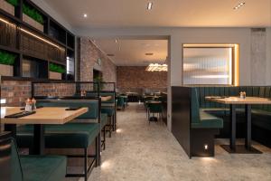 a dining room with tables and green seats at Sandman Signature Glasgow Hotel in Glasgow