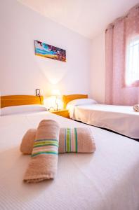 een slaapkamer met 2 bedden en handdoeken op het bed bij Les Olles Riumar Pura Natura in Riumar