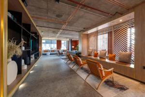 a lobby with a row of chairs and tables at Sandman Signature Glasgow Hotel in Glasgow