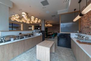a restaurant with a counter with a bench in it at Sandman Signature Glasgow Hotel in Glasgow