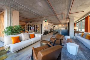 a living room with couches and chairs and a table at Sandman Signature Glasgow Hotel in Glasgow