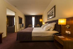 a hotel room with a large bed with pillows at Vila Gale Porto - Centro in Porto