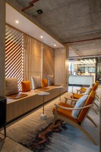 a lobby with couches and chairs in a room at Sandman Signature Glasgow Hotel in Glasgow