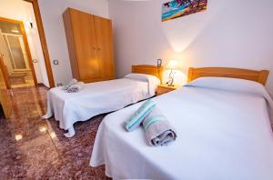 een hotelkamer met 2 bedden en handdoeken erop bij Les Olles Riumar Pura Natura in Riumar
