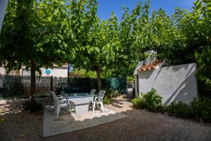 d'une terrasse avec une table et des chaises sous un arbre. dans l'établissement Les Olles Riumar Pura Natura, à Riumar