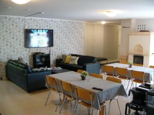 Hotelli Aliisa في Loimaa: غرفة معيشة مع أريكة وطاولة وكراسي