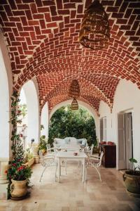 a patio with a table and chairs under a brick ceiling at DAR BELDI in Hammamet
