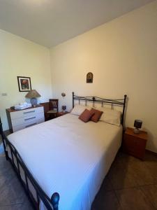 a bedroom with a large white bed and a nightstand at Villa Marletta in Santa Maria di Licodia