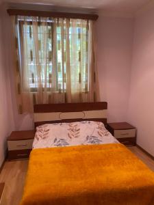 a bedroom with a bed with a yellow blanket on it at Коттедж на берегу оз. Севан in Sevan