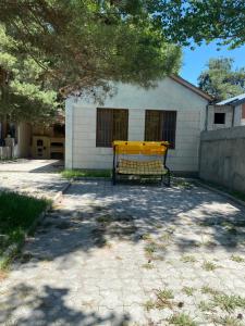 a yellow bench sitting in front of a building at Коттедж на берегу оз. Севан in Sevan