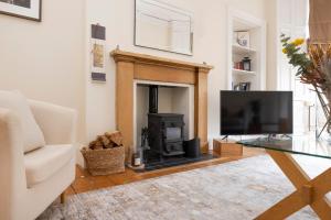 a living room with a fireplace and a tv at Tasteful 1-bedroom Apartment near Edinburgh Meadows in Edinburgh