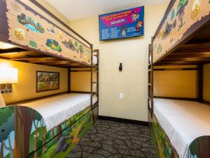 two bunk beds in a room with a sign on the wall at Country Cascades Waterpark Resort in Pigeon Forge