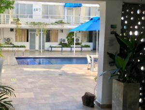 a swimming pool with a blue umbrella in a building at Hotel Casa Victoria Rodadero Reservado in Gaira