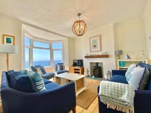 sala de estar con sillas azules y chimenea en 83 Gills Cliff Road en Wroxall