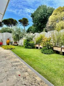 a garden with benches in a yard with grass at CASA MILA White in Marina di Cerveteri