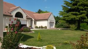 uma casa com um quintal com relva verde em Carnetin Le Parc, Gite et B&B em Thorigny-sur-Marne
