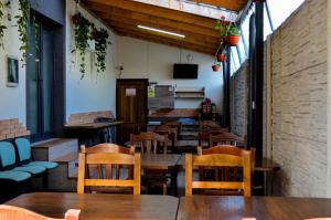 an empty restaurant with wooden tables and chairs at ROMSIL GUESTHOUSE in Costinesti