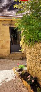 une porte d'une maison avec des fleurs devant elle dans l'établissement La cachette sarladaise, à Sarlat-la-Canéda