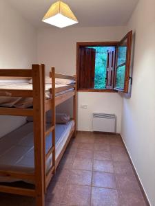 Cette chambre comprend 2 lits superposés et une fenêtre. dans l'établissement Mountain Apartment: Pedraforca, à Saldes