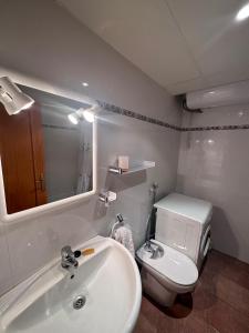 La salle de bains est pourvue de toilettes blanches et d'un lavabo. dans l'établissement Mountain Apartment: Pedraforca, à Saldes