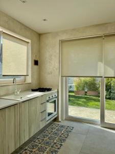 uma cozinha com um lavatório, um fogão e uma janela em CASA MILA em Marina di Cerveteri