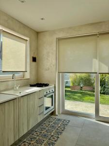 a kitchen with a sink and a stove and a window at CASA MILA White in Marina di Cerveteri +52 photos