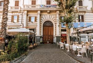 ein Gebäude mit Tischen und Stühlen vor einer Tür in der Unterkunft Gentile Suite & Spa Vomero in Neapel