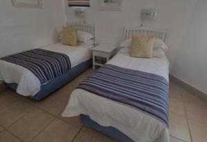 two beds sitting in a room with at Kaliva 394, Club Mykonos in Langebaan