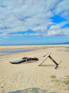 two objects laying on the sand on a beach at Area Surf House in Muros