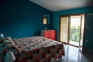 een slaapkamer met een bed, een dressoir en een raam bij B&B DomuSanna in Villaputzu