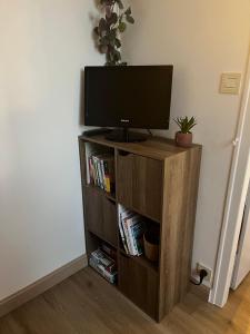 een televisie op een houten standaard in een kamer bij Studio 400m de la mer in Lancieux