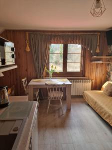 a kitchen and living room with a table and a couch at Gościniec Jawor in Ruciane-Nida