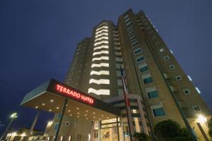 een hoog gebouw met een hotelbord ervoor bij Terrado Suites Iquique in Iquique