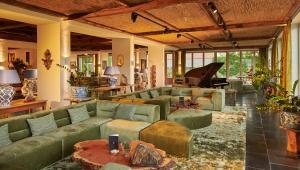 a living room with green couches and a piano at BLEICHE RESORT & SPA in Burg