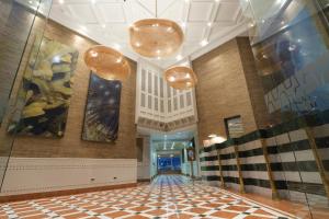a hallway of a building with a checkerboard floor at Terrado Suites Iquique in Iquique