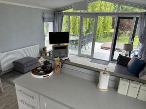 ein Wohnzimmer mit einem Flachbild-TV auf der Theke in der Unterkunft Orchard View Lodge in Woodhall Spa