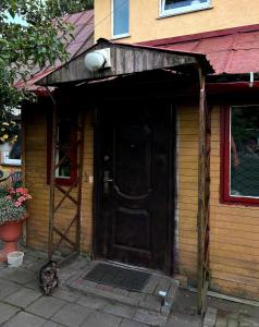 un chat assis à l'extérieur d'une maison avec une porte dans l'établissement Retro bungalow, à Liepāja