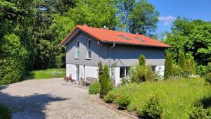 ein blau-weißes Haus mit rotem Dach in der Unterkunft Tegernsee Chalet in Gmund am Tegernsee